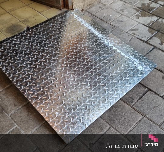 רמפה מתכתית עם דוגמת יהלומים על מדרכה